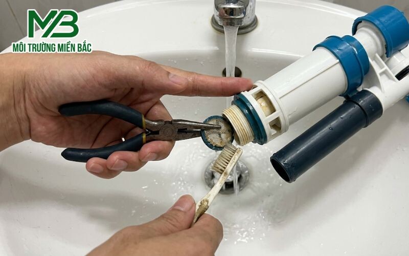 Dùng kìm rút màng lọc van cấp nước ra ngoài và vệ sinh sạch cặn bẩn